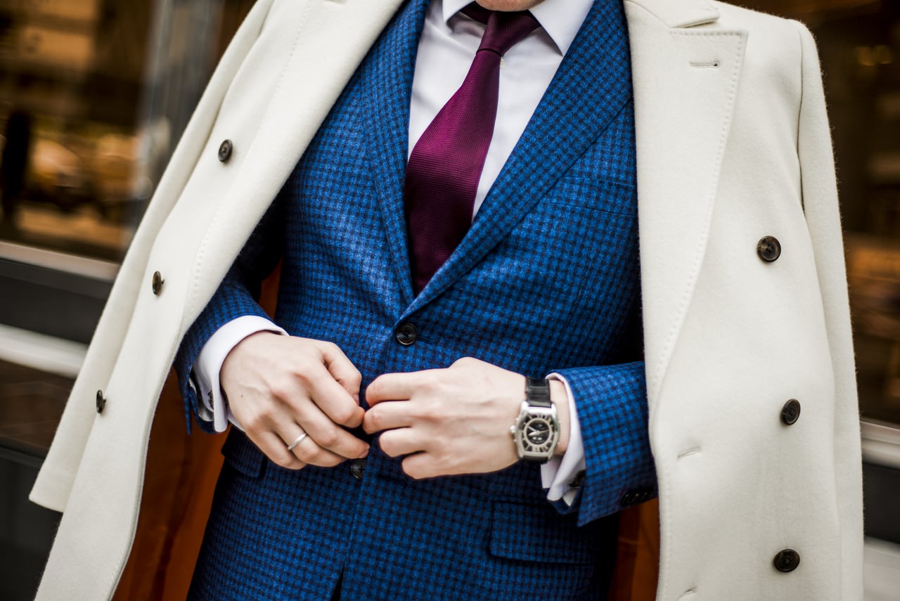 Мужчина в пиджаке в клетку, красном галстуке и белом пальто